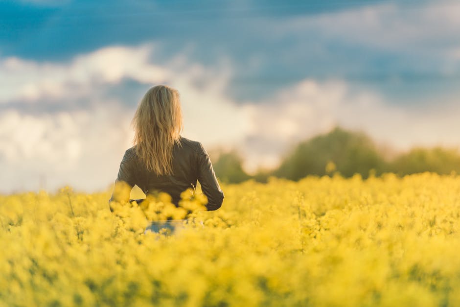 woman standing in field of flowers
